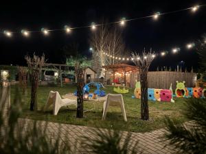 einen Spielplatz in einem Park bei Nacht mit Lichtern in der Unterkunft DOMKI LAURA z sauną i gorącą balią z jacuzzi in Jastrzębia Góra