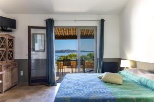 a bedroom with a bed and a view of the ocean at Résidence U Paviddonu in Porto-Vecchio