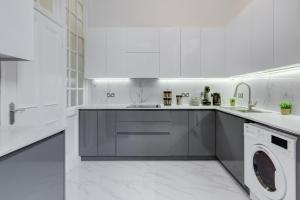 una cocina blanca con lavadora y secadora. en Stylish 3 Bedroom Luxury Apartment in Harley St 3, en Londres