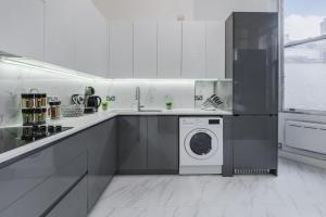 a white kitchen with a washing machine in it at Stylish 3 Bedroom Luxury Apartment in Harley St 3 in London