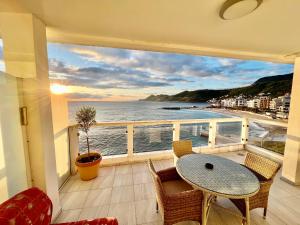 balcón con mesa, sillas y vistas al océano en Apartments AriaSana, en Dobra Voda