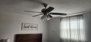 a ceiling fan in a living room with a window at Harvest Haven in Niagara Falls