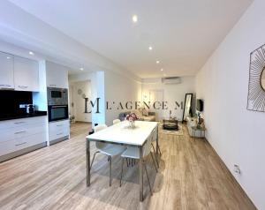 a kitchen and living room with a white table in a room at Appartement Saint-Antoine, paisible in Calvi