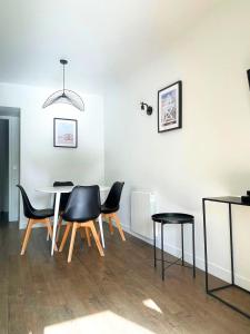 a dining room with black chairs and a table at Appartement 1 Chambre 4 Pers - Piscine Chauffé - Parking Gratuit - Vue Golf Deauville - La Deauvillaise Résidence du Golf in Deauville