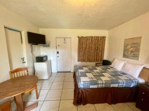 een hotelkamer met een bed, een tafel en een deur bij Ocean Holiday Motel in Daytona Beach