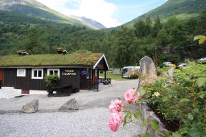 a small building with a grass roof on a mountain at Vinje Camping in Geiranger