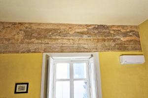 Habitación con ventana y pared de ladrillo en Residenza Palazzo Miraldi-Ferrari, en Cava deʼ Tirreni