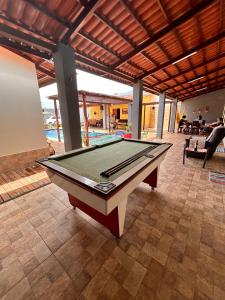 a pool table in the middle of a room with a swimming pool at Brisa do Sol in Cascavel