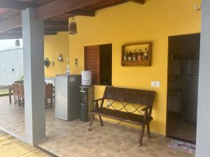 a bench in a kitchen with a yellow wall at Brisa do Sol in Cascavel +8 photos