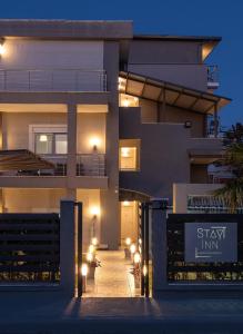 una fachada de una casa por la noche con luces en StayInn Luxury Apartments en Nea Kallikratia