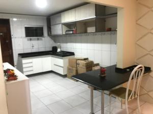 eine Küche mit einem schwarzen Tisch und weißen Geräten in der Unterkunft Casa de Temporada no Maior São João do Mundo in Campina Grande