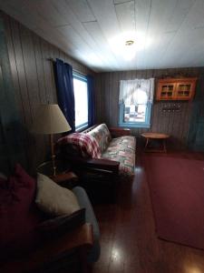 sala de estar con sofá y mesa en Adirondack Retreat, en Bakers Mills