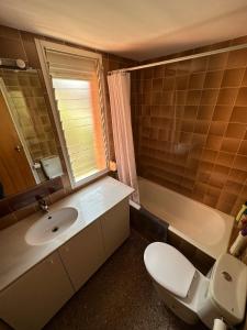 een badkamer met een toilet, een wastafel en een spiegel bij Apartamento 2 habitaciones Cap Salou in Salou