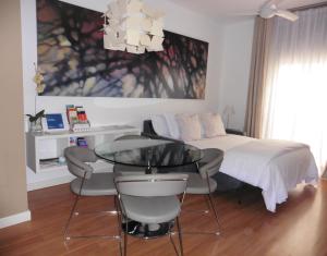 マラガにあるApartamento Barrio Picassoのベッドルーム1室(ベッド1台、テーブル、椅子付)