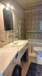 een badkamer met een wastafel, een toilet en een bad bij Apartament Morskie Oko in Brodnica