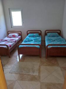 3 camas individuales en una habitación con ventana en Bujtina Aliaj, en Tropojë