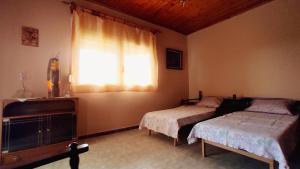 a bedroom with two beds and a window at Polis Houses in Nea Iraklia