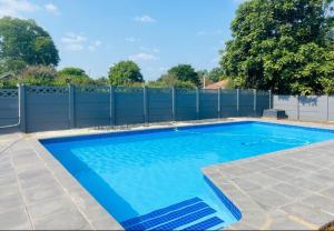 a swimming pool in a yard with a fence at Alberta Bed and Breakfast in Pietermaritzburg