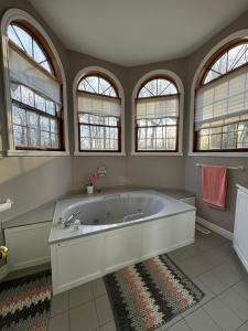 a large bathroom with a large tub with windows at Marley's home in Woodlawn