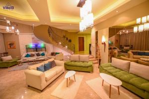 una gran sala de estar con sofás y una escalera. en Villa 13 Luxury suites en El Cairo