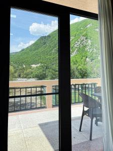 einen Blick aus dem Fenster eines Balkons mit einem Tisch in der Unterkunft Khidikari Hotel in Ambrolauri