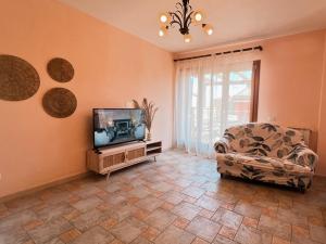 a living room with a tv and a couch at Villa La Terrazza in Porto Santo Stefano