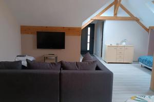 a living room with a couch and a flat screen tv at Appartement Les Ondines 4 pers. in Lemberg