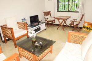 a living room with a couch and a table and chairs at Beatrice James airbnb Moshi in Moshi