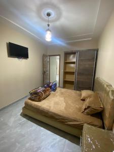 una camera con un grande letto e una TV di Appartement karakcho a Berkane
