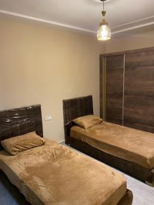 una camera con due letti e un lampadario a braccio di Appartement karakcho a Berkane