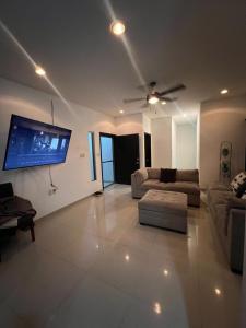 博卡德爾里奧的住宿－Casa Palma，客厅配有沙发和墙上的电视