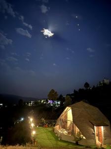 a tent in a field at night at The Soul Stroll Cottages Retreat in Mukteshwar