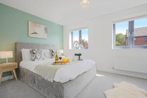 a bedroom with a large bed with a tray of fruit on it at Wavendon Retreat - Sleeps 6 - Free Parking, Fast Wifi and Smart TV by YOKO PROPERTY in Milton Keynes