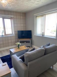 a living room with a couch and a tv at Olympic Place 1-bed Apartment in Rowley Regis