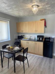 a kitchen with a table and chairs in a room at Olympic Place 1-bed Apartment in Rowley Regis