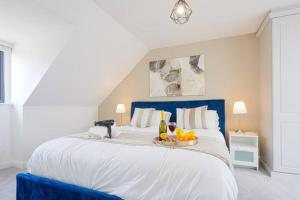 un grande letto bianco con un vassoio di cibo sopra di Wavendon Retreat - Sleeps 6 - Free Parking, Fast Wifi and Smart TV by YOKO PROPERTY a Milton Keynes