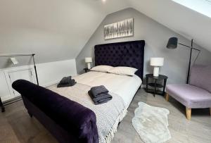 um quarto com uma cama grande e uma cadeira em Gorgeous Loft Room em Beckenham
