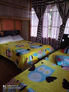 ein Schlafzimmer mit 2 Betten mit Blumen drauf in der Unterkunft Hermosa casa campestre in Popayan