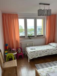 Habitación pequeña con 2 camas y ventana en Apartament Centrum, en Suwałki