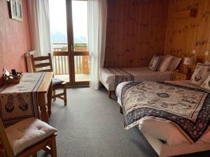 a hotel room with two beds and a balcony at Hotels Les Catrems & Le Montagnou in Orcières