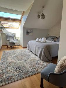 1 dormitorio con 1 cama, 1 silla y 1 alfombra en Coqueto Ático centro Begoña en Gijón