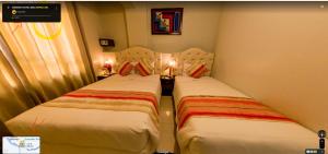 2 letti posti uno accanto all'altro in una stanza di ANDINO HOTEL MACHUPICCHu a Machu Picchu