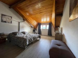 sypialnia z łóżkiem i kanapą w obiekcie Location vacances Barcelonette w mieście Barcelonnette