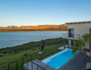 a building with a statue next to a body of water at Lavender Dreams - Villa 111 in Hermanus