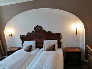 2 Betten in einem Schlafzimmer mit Torbogen in der Unterkunft Historisches Hotel Bären in Kiental