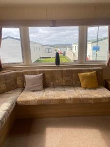 a couch in a room with a large window at 15 Maple Rise in Gristhorpe