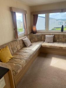 ein Sofa im Wohnzimmer mit einem großen Fenster in der Unterkunft 15 Maple Rise in Gristhorpe