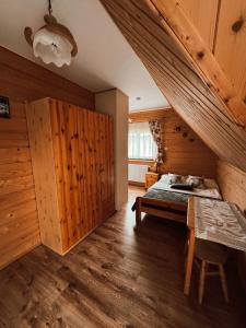 sypialnia z drewnianymi ścianami i łóżkiem w pokoju w obiekcie Domek Przy Potoku w Murzasichlu