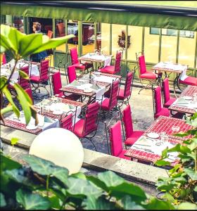 uma fila de mesas e cadeiras com cadeiras cor-de-rosa em Hotel Manos Premier em Bruxelas