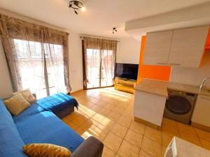 a living room with a blue couch and a kitchen at Buen Camino El Cotillo in El Cotillo